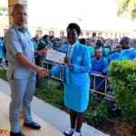 Deputy Head teacher handing over certificate to Junior Achiever's participant